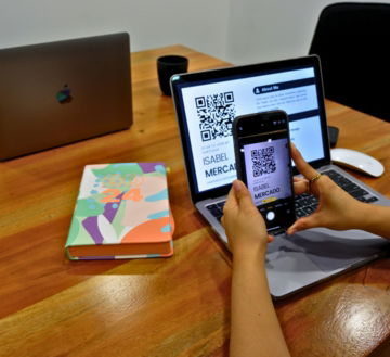 a person sitting at a table with a laptop and a cell phone